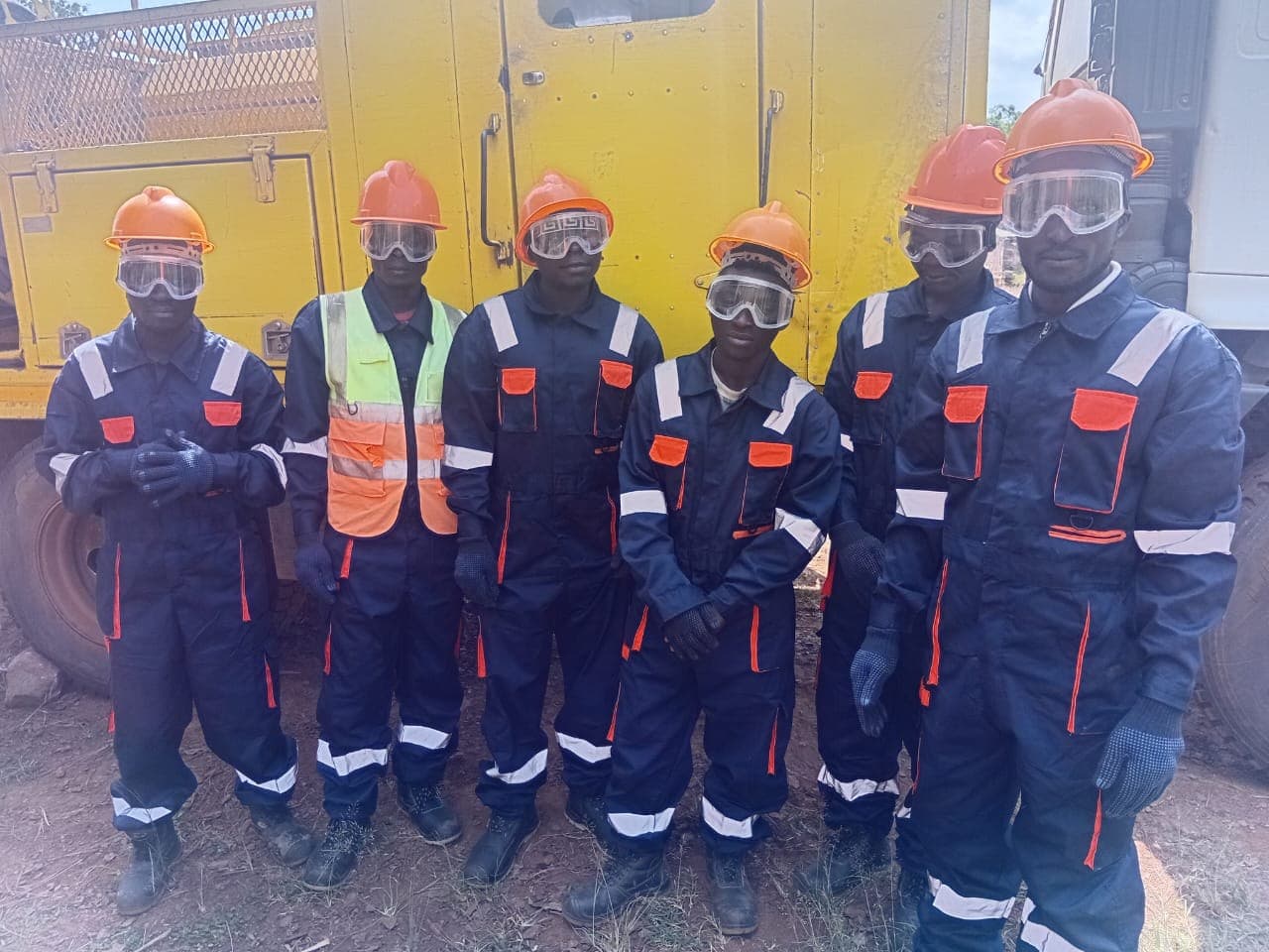 Six Kwabakya workers in overalls, helmets, goggles and gloves